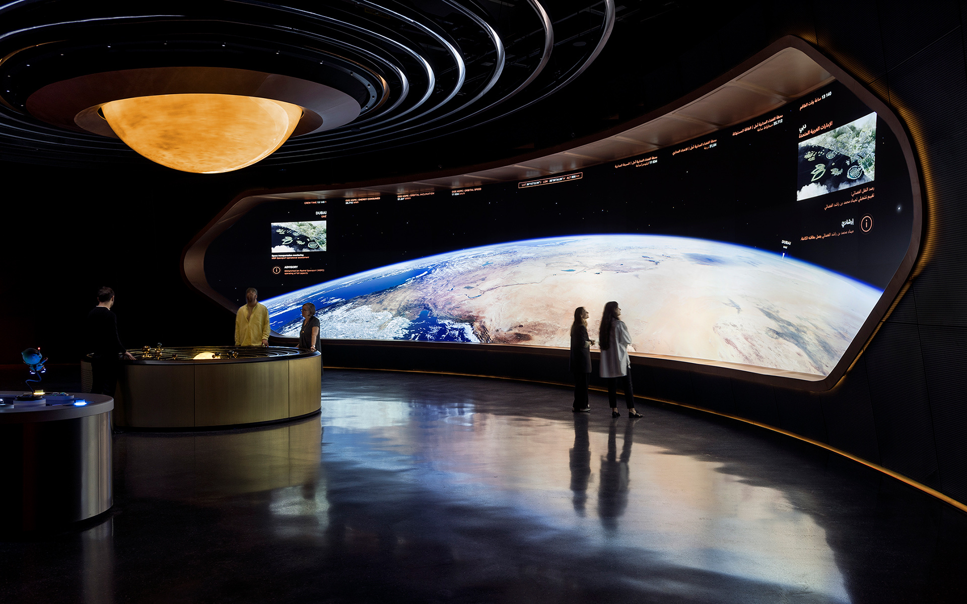 The Library of Hope inside the HEAL Institute pavilion: a softly lit circular chamber with rows of glowing glass vials arranged on backlit shelves around a central viewing platform, evoking a seed bank for endangered species.